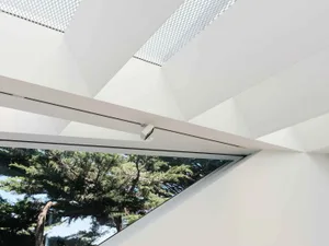 Modern interior design with glass and concrete elements, featuring white geometric patterns on the ceiling.