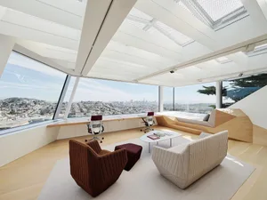Contemporary living room featuring white walls, large glass windows, and minimalist furniture.