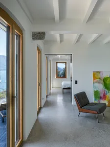 A modern minimalist bedroom featuring minimalist furniture on concrete floor, overlooking mountains.