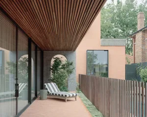 A modern residential exterior with concrete accents and a wooden roof.