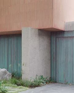 Modern building exterior featuring concrete panels and metal railings.