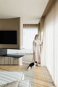 Modern interior design featuring a living room with white curtains, wood flooring, and minimalistic decor.