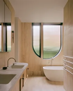 A modern bathroom with marble finishes and a freestanding bathtub.