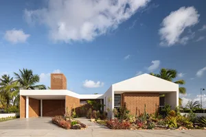 Modern minimalist house featuring brick and concrete exterior with glass windows.