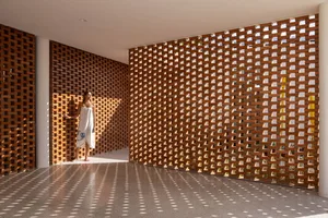 A woman standing in a room with modern interior design featuring brick walls.