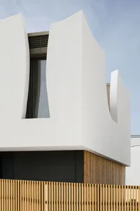 A modern white building exterior with unique architectural features.