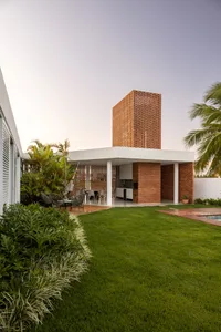 Modern residential exterior of a house featuring brick walls, glass windows, and wooden elements.
