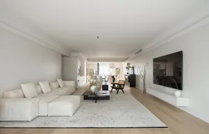 A modern minimalist living room with a neutral color palette.