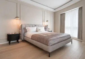 A minimalist bedroom with a modern bed and elegant fabric decor.