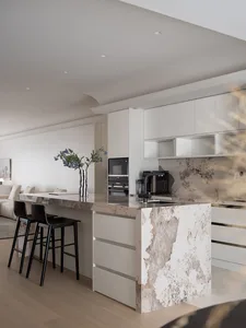 A modern kitchen with a marble countertop and black stools.