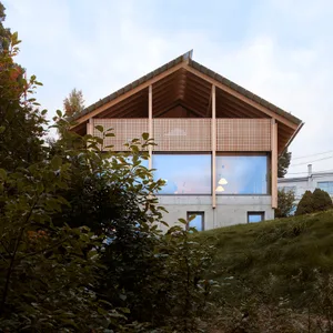 Modern residential exterior with a wooden exterior and large windows.