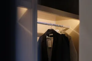 Clothing closet with metal hangers and lighting