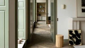 A modern living room with wood flooring and green doors.