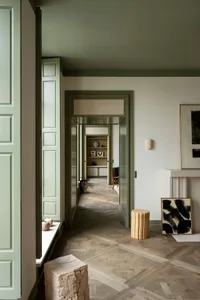 A contemporary minimalist living room featuring a wooden floor with a geometric parquet pattern.