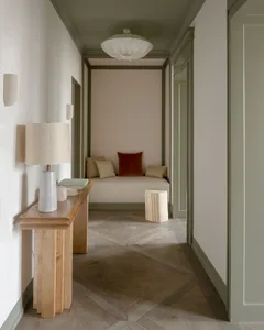 A modern minimalist living room showcasing wooden accents and a cozy seating area.