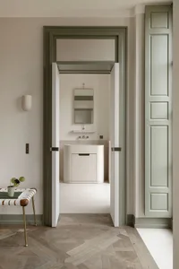 Modern bathroom design featuring oak wood paneling, light fixtures, and a sleek white vanity.