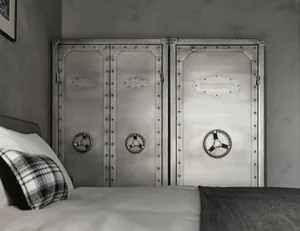 A metal headboard with industrial design elements in a bedroom setting.