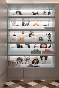 A modern interior design featuring a backlit bookshelf displaying books, storage boxes, and decorative items.