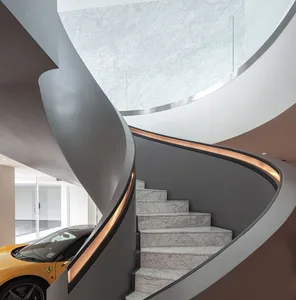 A modern residential staircase with marble steps and a sleek, curved design.