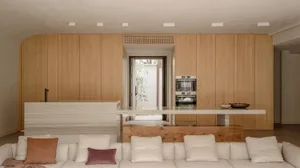 A modern interior with wooden panels, white couch, and white countertop.