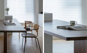 Modern minimalist dining room featuring a long wooden dining table with a concrete countertop, minimalistic furniture, and a 