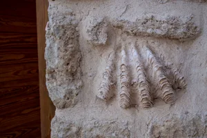 Ancient stone mural depicting a handprint with three fingers.