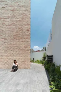 A modern residential exterior with concrete walls and a stone pathway.