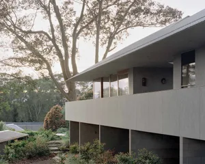 An exterior residential design featuring modern architectural elements and concrete materials.