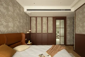A modern bedroom with a brown leather headboard, a glass door, and floral wallpaper.