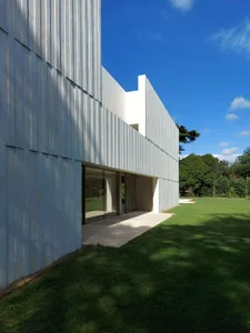 Modern house exterior with metal cladding and large glass windows.