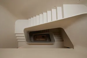 A modern staircase constructed of concrete, featuring clean lines and a spiral design.