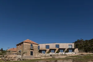 A modern residential building featuring stone and wooden materials.