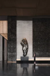 A minimalist lobby featuring a metal sculpture of a horse head.
