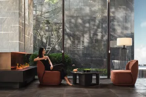 A modern minimalist living room with wooden furniture, glass windows, and a glass table.