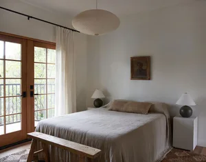A minimalist bedroom with a bed made of cotton and linen blend sheets.