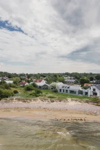 A coastal town with modern beach homes featuring glass, wooden, and metallic architectural elements.