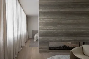 Modern minimalist bedroom featuring a concrete fireplace with a neutral color palette and minimalistic design.