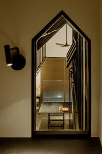 A minimalist office space with a wooden desk and glass wall, viewed through a large window.