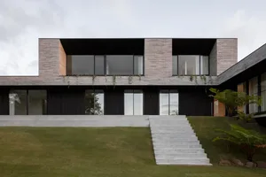 Modern residential building with brick exterior and large glass windows.