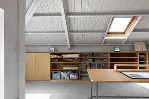 Workshop with minimalist design, featuring wooden shelving and storage units.