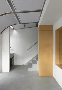 Modern staircase with concrete steps, metal railing, and industrial lighting.