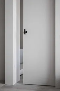 A minimalist doorway with a concrete wall and minimalist door handle.