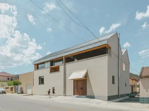 Modern residential house with minimalist design featuring concrete and metal materials.