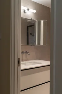 Modern minimalist bathroom with white subway tiles and sleek white fixtures.