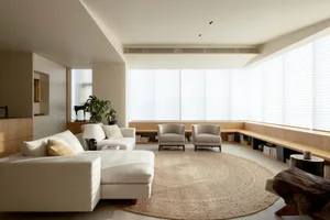 Contemporary living room with a white sectional sofa, round cushions, and a large circular rug.