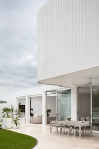 A modern residential home with a white prefabricated panel exterior.