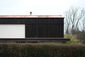 Modern black wooden and concrete exterior building with a minimalist design.
