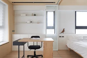A minimalist bedroom featuring wood furnishings and mixed materials.