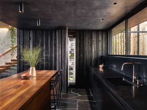 Modern industrial kitchen with black marble and black concrete countertops and black wood cabinets