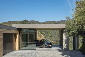 A modern residential exterior featuring concrete and glass materials.